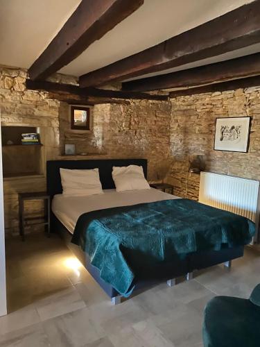 une chambre avec un grand lit dans un mur de briques dans l'établissement Magnone Vacance - Gîte Belle Vue, à Lavercantière