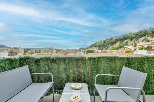 un patio avec deux chaises et une table sur un balcon dans l'établissement Amazing 1BR Flat with balcony and city view in Haut de Nice, à Nice