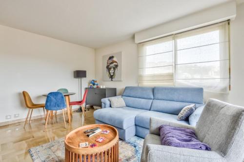 un salon avec un canapé bleu et une table dans l'établissement Amazing 1BR Flat with balcony and city view in Haut de Nice, à Nice