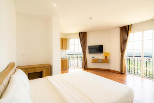 a bedroom with a large bed and a large window at Ocean Hill Lodge Phú Quốc in Phu Quoc