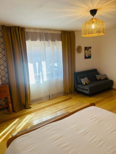 a living room with a couch and a large window at Casa "La Moara din Grădină" in Eftimie Murgu