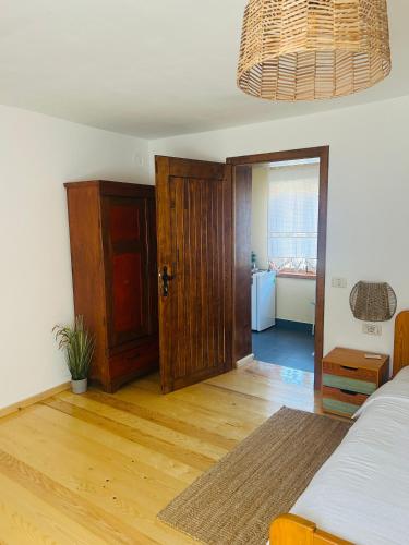 a bedroom with a bed and a wooden door at Casa "La Moara din Grădină" in Eftimie Murgu
