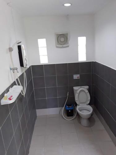 a bathroom with a toilet and a phone on the wall at Carpe Diem Guest House in Ko Chang