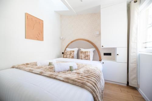 - une chambre blanche avec un grand lit et une couverture dans l'établissement Dreamyflat - Archives, à Paris