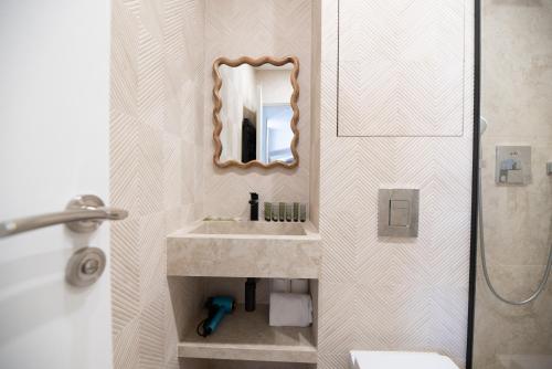 une salle de bain avec un lavabo et un miroir dans l'établissement Dreamyflat - Archives, à Paris