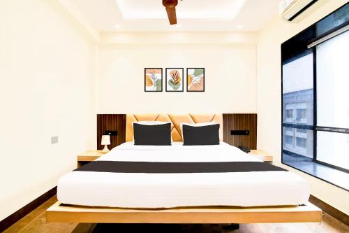a bedroom with a large bed and a large window at Super Townhouse New Town Near DLF in Kolkata
