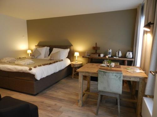 une chambre d'hôtel avec un lit et une table dans l'établissement B&B De Swaenhoeck, à Damme
