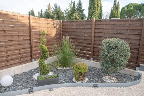 a privacy fence with two plants in a yard at L'étincelle in Saint-Christol-lès-Alès