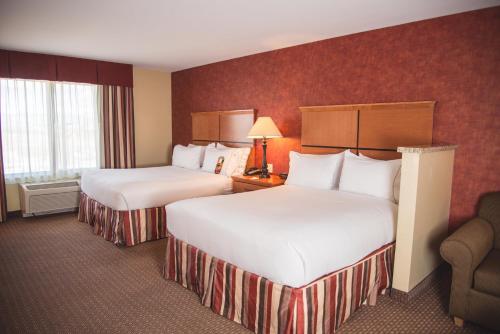 a hotel room with two beds and a chair at Holiday Inn Express Hotel & Suites Loveland by IHG in Loveland