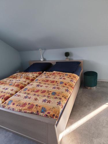 a bed with a comforter on it in a bedroom at Ferienwohnung Hartmann in Wernigerode
