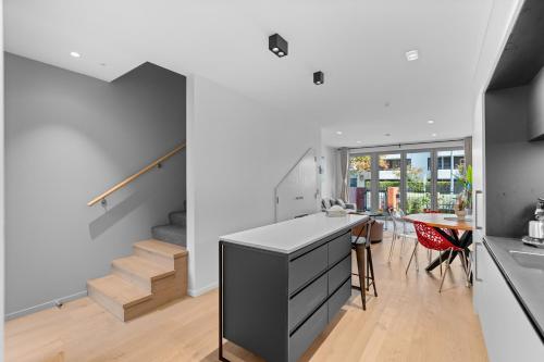 a kitchen and dining room with a staircase in a house at Heart of Our Garden City in Christchurch
