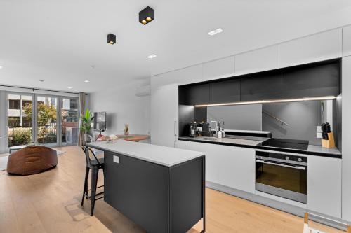 a kitchen with black and white cabinets and a counter at Heart of Our Garden City in Christchurch