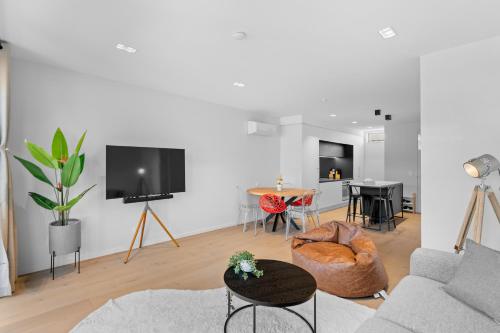 a living room with a couch and a tv at Heart of Our Garden City in Christchurch