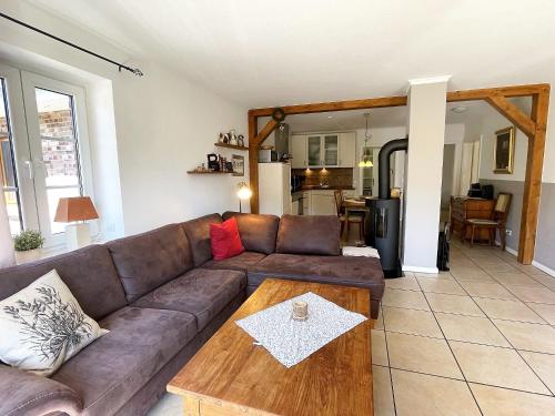 un salon avec un canapé marron et une table dans l'établissement Ferienhaus Marie Rodenäs, à Rodenäs