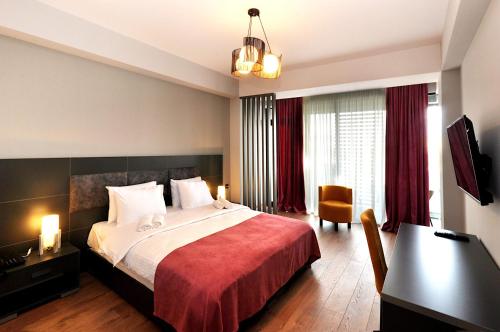 a bedroom with a large bed with a red blanket at Jazz Hotel in Tbilisi City