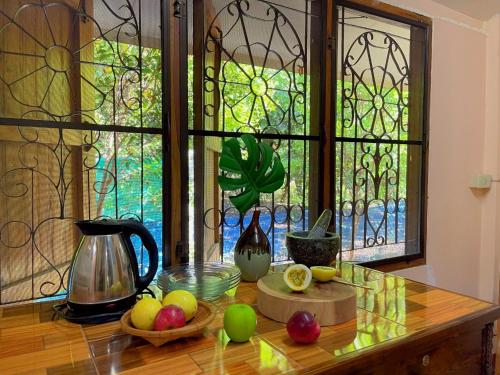 a table with fruit on it in front of a window at Chompor Homestay in Chiang Dao