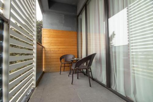 a balcony with two chairs and a table on it at Jazz Hotel in Tbilisi City