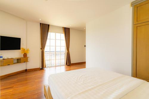 a bedroom with a bed and a flat screen tv at Ocean Hill Lodge Phú Quốc in Phu Quoc