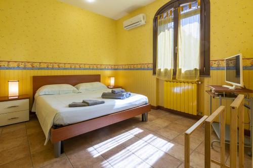 a bedroom with a bed with yellow walls and a window at Villa Luna e' Pedra - Suites Esclusive in Villa con Vista sulla Baia di Alghero e Piscina, Jacuzzi privata in Alghero