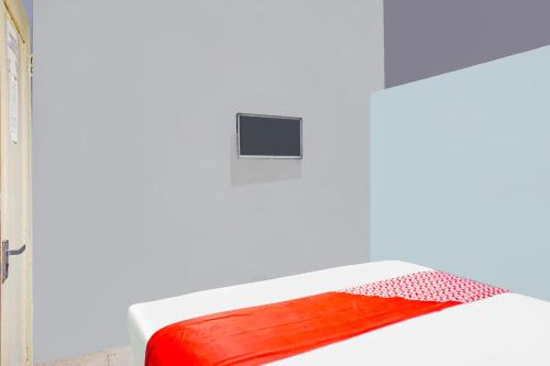 a bed with a red and white blanket on it at Hotel O Mandala Near Universitas Negeri Medan UNIMED in Medan