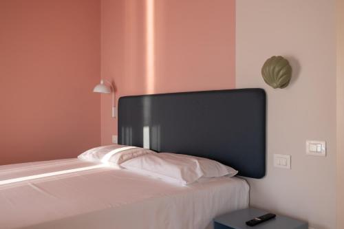 a bed with a black headboard in a room at La Vista Postcard Hotel in Lazise
