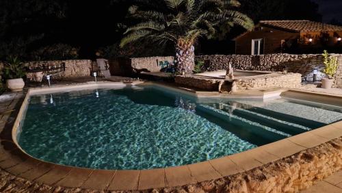 - une grande piscine d'eau bleue la nuit dans l'établissement Villa provençale, à Châteaurenard