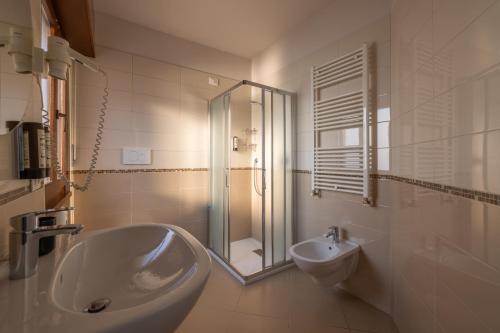a bathroom with a sink and a shower and a toilet at La Vista Postcard Hotel in Lazise