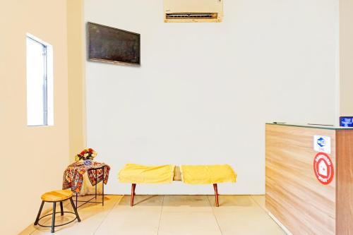 a room with a table and two chairs and a refrigerator at Hotel O Mandala Near Universitas Negeri Medan UNIMED in Medan