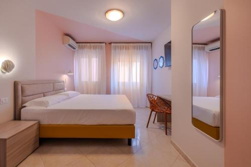 a bedroom with a bed and a table and a mirror at La Vista Postcard Hotel in Lazise