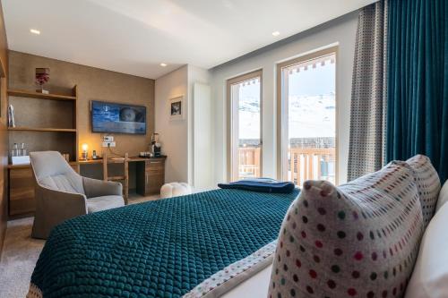 a bedroom with a large green bed with a window at Hotel Pashmina Le Refuge in Val Thorens