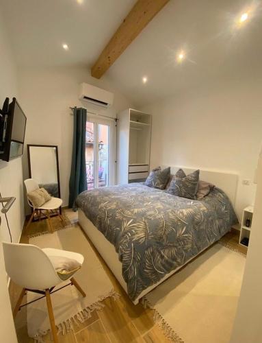 une chambre avec un lit, une chaise et une fenêtre dans l'établissement MAISON DE VILLAGE - Climatisée - avec Terrasse, à La Turbie