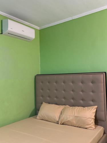 a bed in a room with a green wall at Comfort Haven Guesthouse in Bengcag