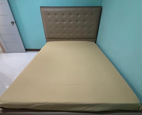 a mattress bed in a room with a blue wall at Comfort Haven Guesthouse in Bengcag
