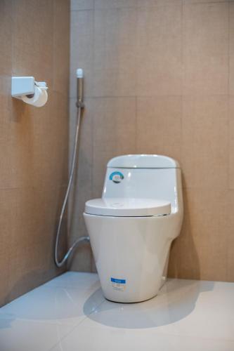 a white toilet in a bathroom with a shower at Bintang Bungalow in Nusa Penida