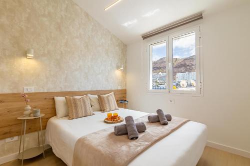 ein Schlafzimmer mit einem großen weißen Bett mit einem Fenster in der Unterkunft HORIZON VACATION HOME - Yucatán Coastal Oasis in Mogán