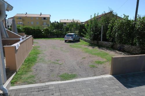 a car parked in a parking lot in a yard at Renoviertes Ferienhaus In Baska Mit Terrasse in Baška