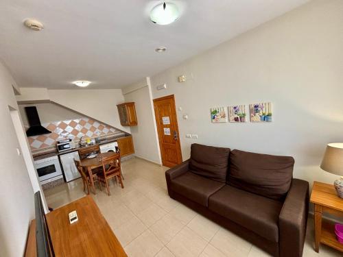 a living room with a couch and a kitchen at Aparthotel Bahia Pinosol in Jávea