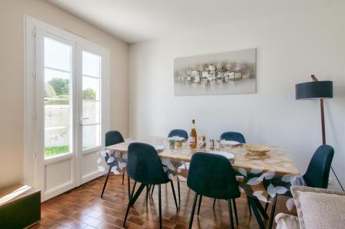 une salle à manger avec une table et des chaises vertes dans l'établissement Jolie maison pour 4, avec jardin, à Ars-en-Ré, à Ars-en-Ré