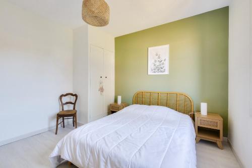 une chambre avec un grand lit et une chaise dans l'établissement Jolie maison pour 4, avec jardin, à Ars-en-Ré, à Ars-en-Ré