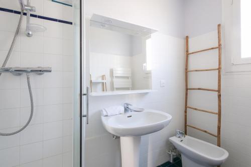 une salle de bain blanche avec un lavabo et une douche dans l'établissement Jolie maison pour 4, avec jardin, à Ars-en-Ré, à Ars-en-Ré