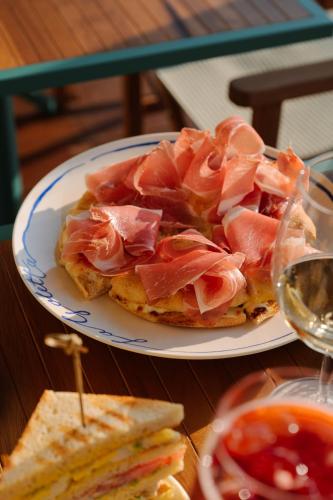 a plate of food with ham on top of a sandwich at Grand Hotel Villa Serbelloni - A Legendary Hotel in Bellagio