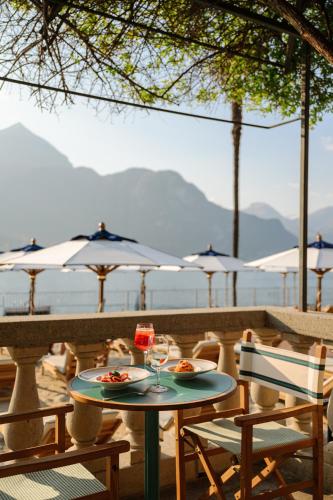 a table with two plates of food and glasses of wine at Grand Hotel Villa Serbelloni - A Legendary Hotel in Bellagio