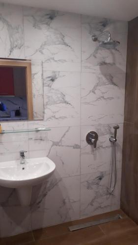 a bathroom with a sink and a white marble wall at ТЕС Боровец Гарденс in Borovets