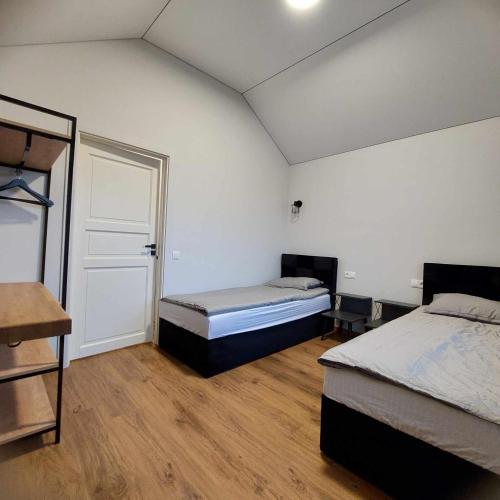 a bedroom with two beds and a door to a room at Kuršių šešetas in Palanga