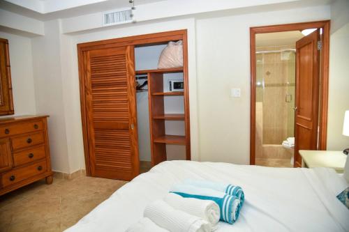 CupecoyTranquil Oceanside: Pools & Direct Beach Access的一间卧室配有一张床和一个带毛巾的衣柜