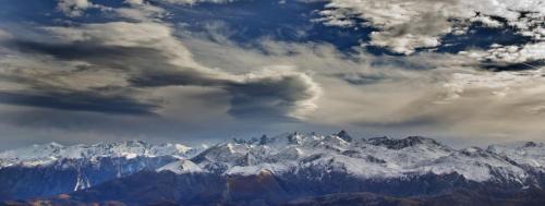 a view of snow covered mountains under a cloudy sky at Apartamentos la Regoria in Arenas de Cabrales