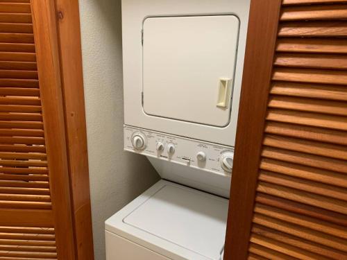 a small kitchen with a television in a room at Tranquil Oceanside: Pools & Direct Beach Access in Lowlands