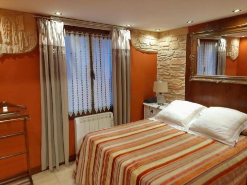 a bedroom with a large bed and a mirror at Errotaetxe Mundaka in Mundaka