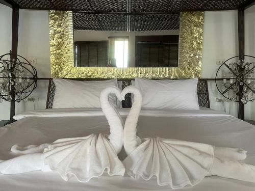 two swans making a heart shape on a bed at Tranquil lake view villa on Phuket golf estate in Kathu