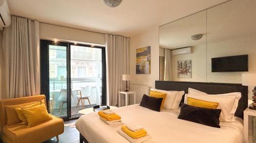 une chambre avec un lit, une chaise et une fenêtre dans l'établissement Studio Victoria 200 m Carlton Hotel & Croisette, à Cannes